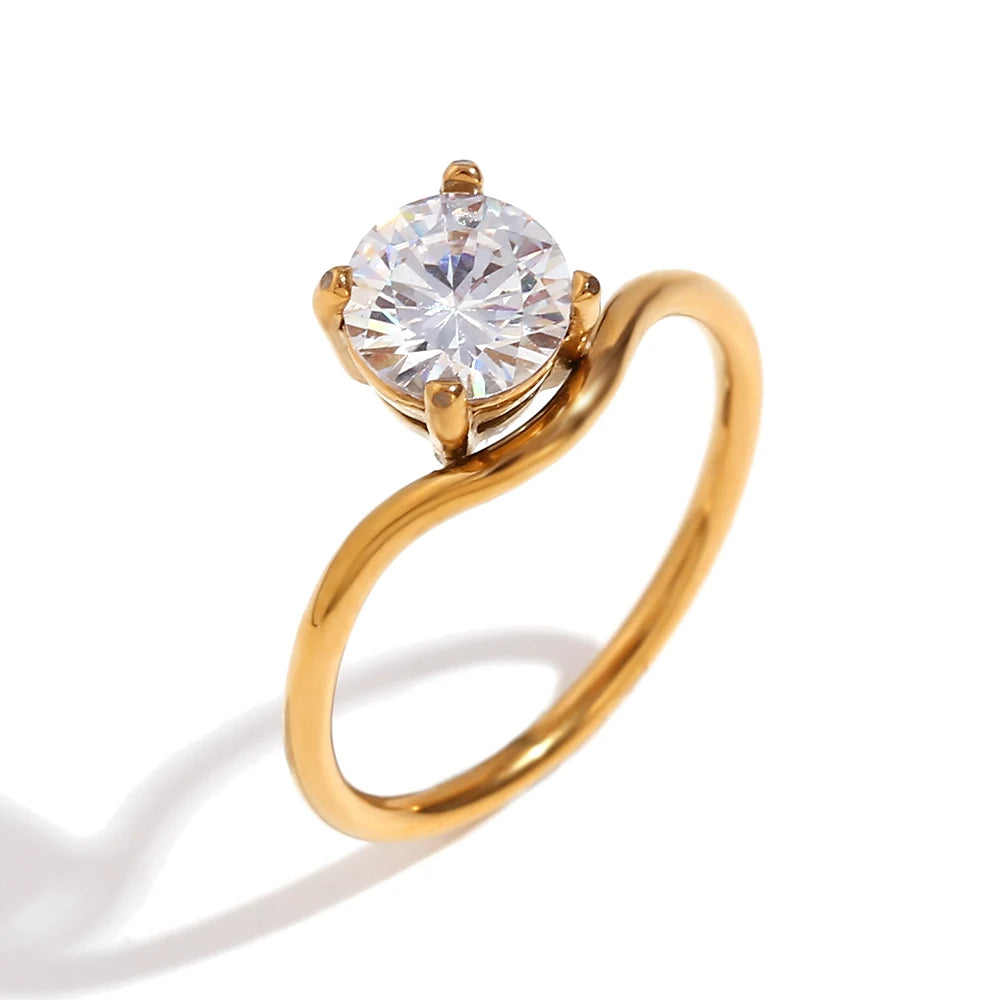 A minimalist gold steel ring with a large round central crystal, set on a simple band.