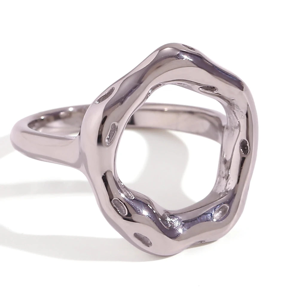 A stainless steel, circle-shaped ring with a textured, asymmetric design, resembling a stylized representation of life's cycles.