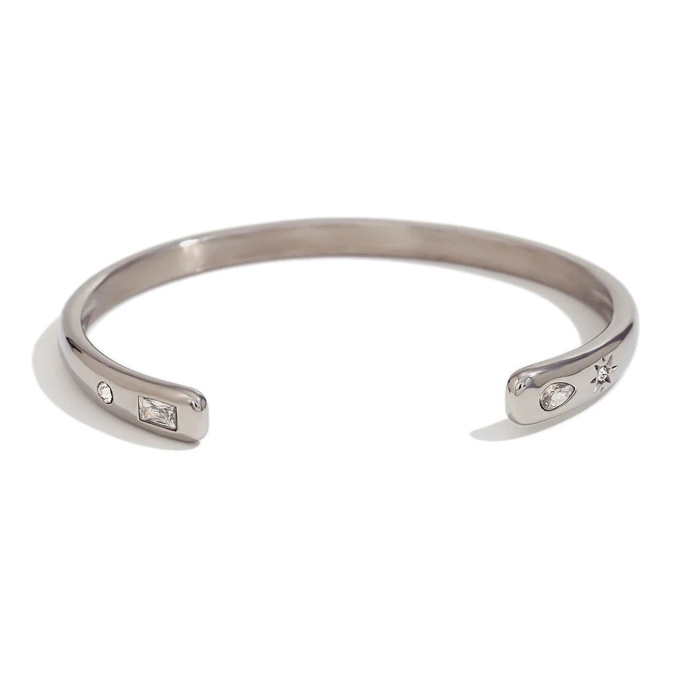 A silver cuff bracelet with clear crystals embedded on the sides