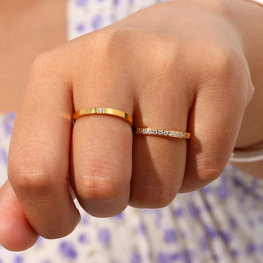 Close-up ofsomeone wearing two gold rings with gemstones