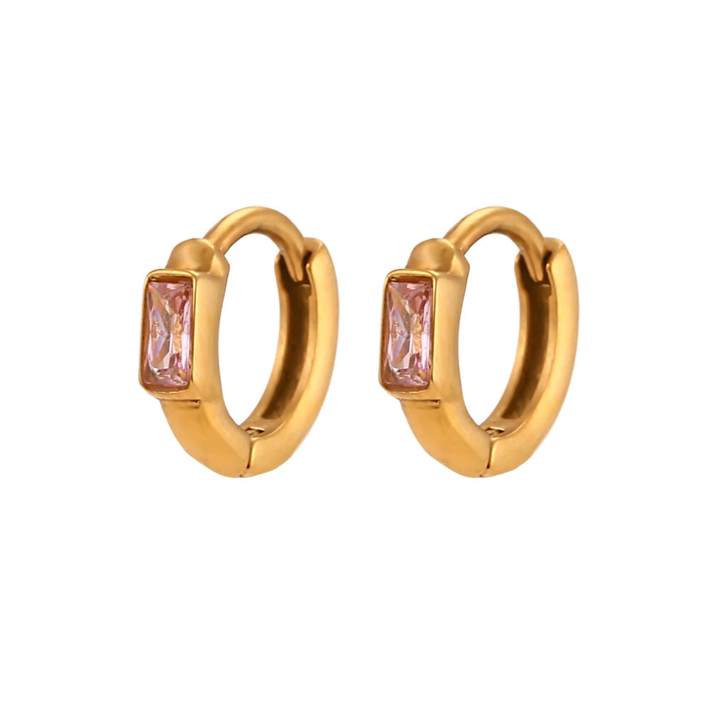 Gold hoop earrings with pink gemstones on a white background