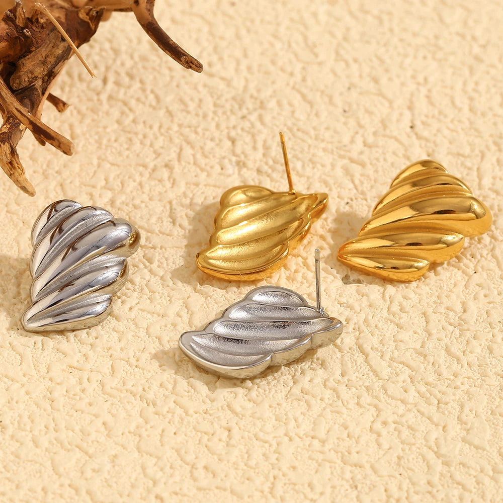 A pair of silver and 18K gold plated stainless steel earrings with a sculpted, wave-like design from the backside