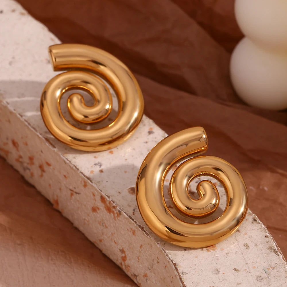 A pair of 18K gold plated stainless steel earrings with a spiral design on display