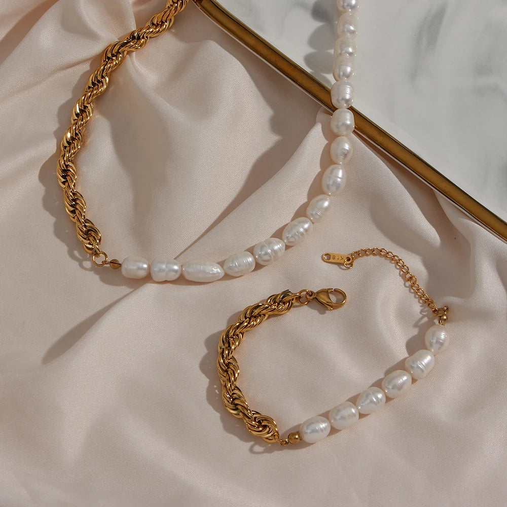 Gold chain and pearl bracelet on a soft pink fabric background