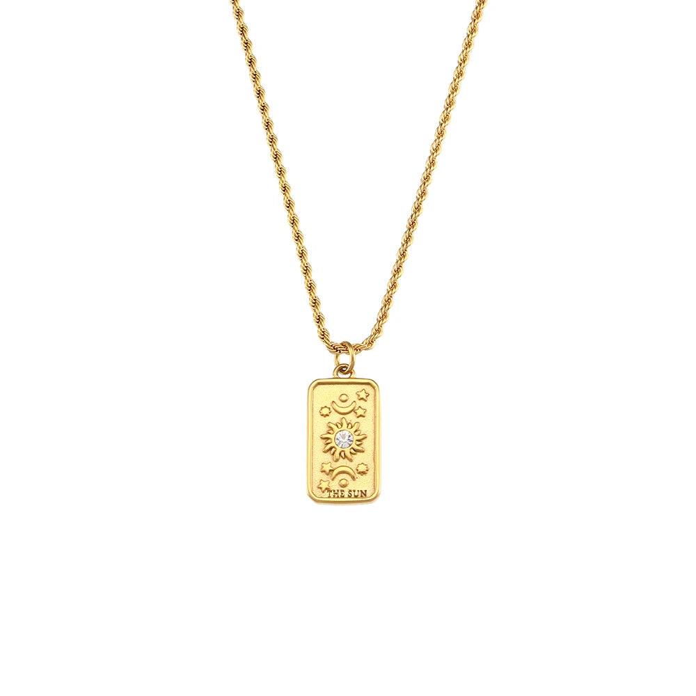 A gold-colored necklace featuring a tarot card pendant, displayed on a white background.