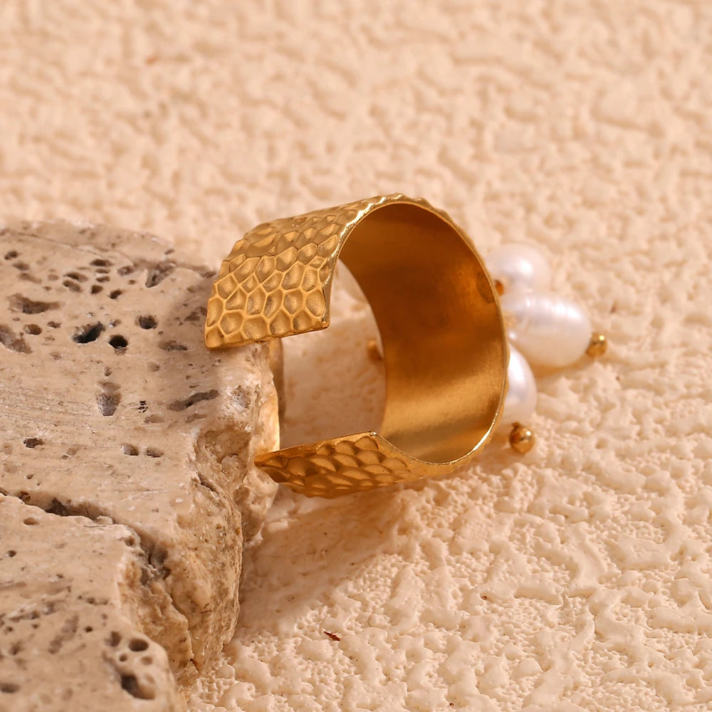 An 18K gold plated stainless steel ring with natural pearl embellishments, featuring a textured design and an adjustable band.