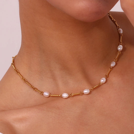 A necklace with golden bars and natural pearls, showing a close-up model