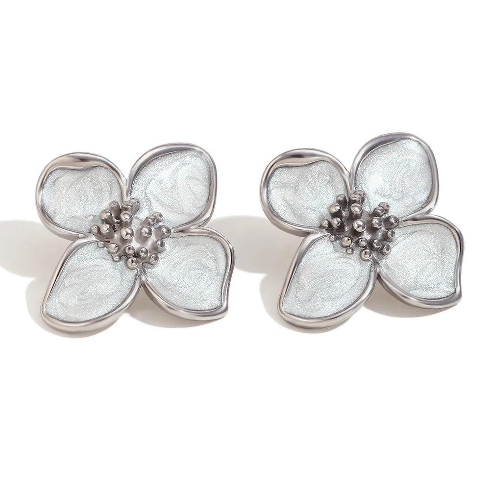 A pair of stainless steel floral earrings with white enamel petals.