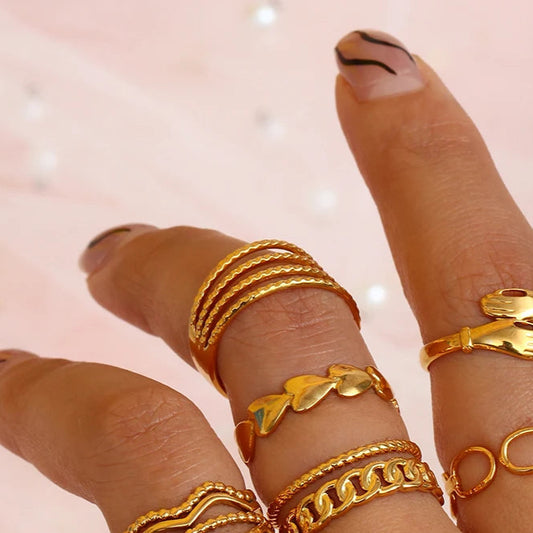 A gold-coated stainless steel ring with four bands that are merging into one, on model