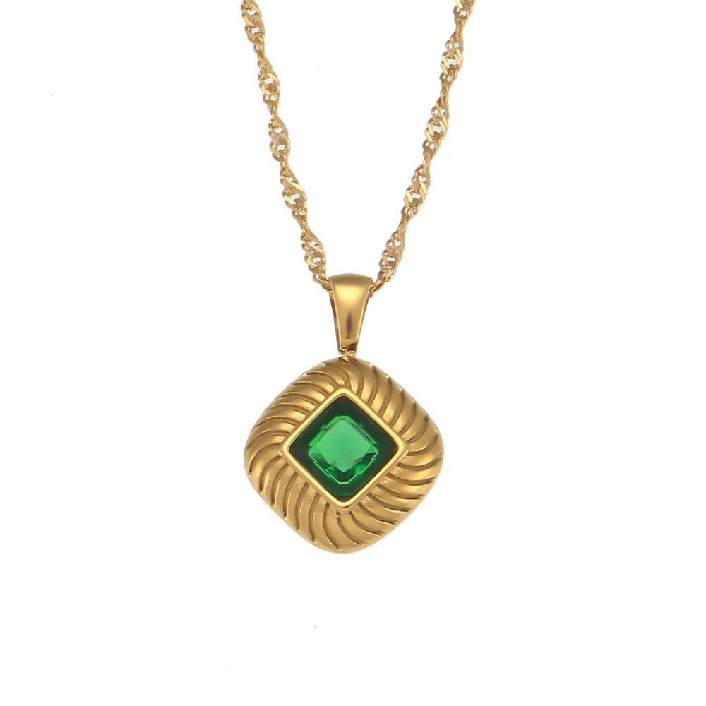 A gold-plated stainless steel necklace with a square pendant featuring a green crystal, on a white background.