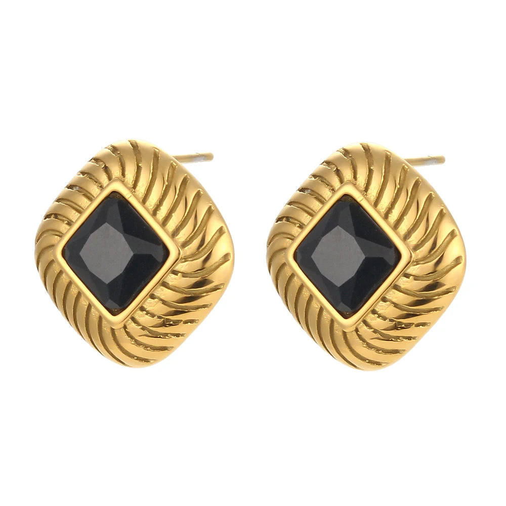 A pair of stainless steel stud earrings with a geometric design and a central black crystal, displayed on a white background.
