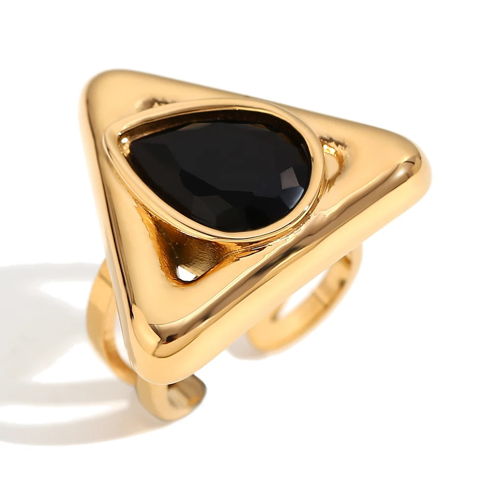 An gold stainless steel ring with a triangular design and a large, black zirconia centerpiece.