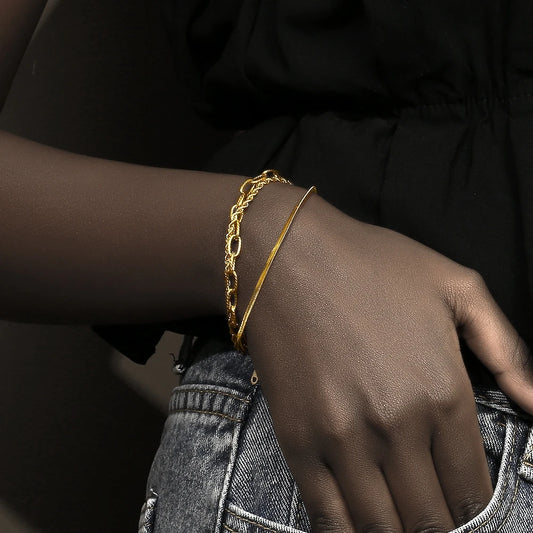 A waterproof bracelet made of three unique gold chains on a model's wrist