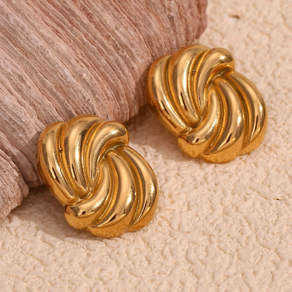 A pair of timeless gold earrings with a twisted design, crafted from 18K gold plated stainless steel closeup