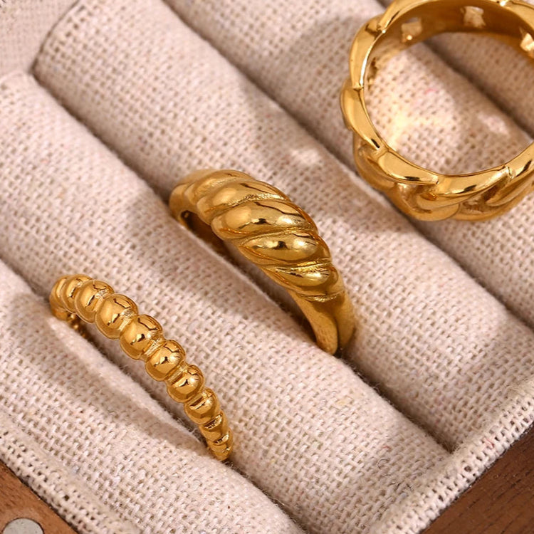 A modern gold stainless steel ring with a wrapped band.