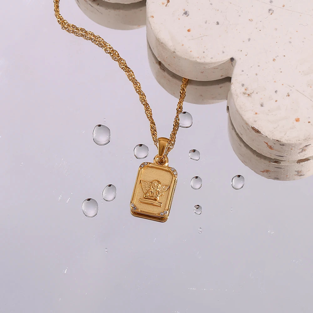 A gold-plated stainless steel necklace with a square pendant featuring an angel figure, surrounded by cubic zirconia on the corners.