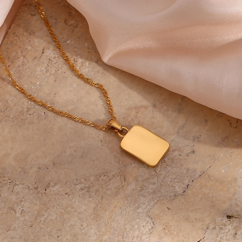 A gold-plated stainless steel necklace with a square pendant featuring an angel figure, surrounded by cubic zirconia on the corners.