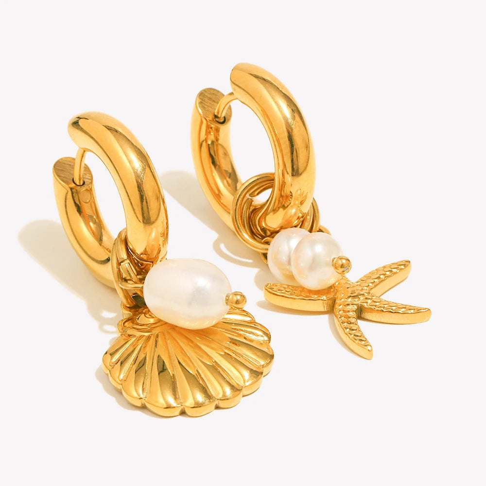 Gold hoop earrings with pearl and shell charms on a white background
