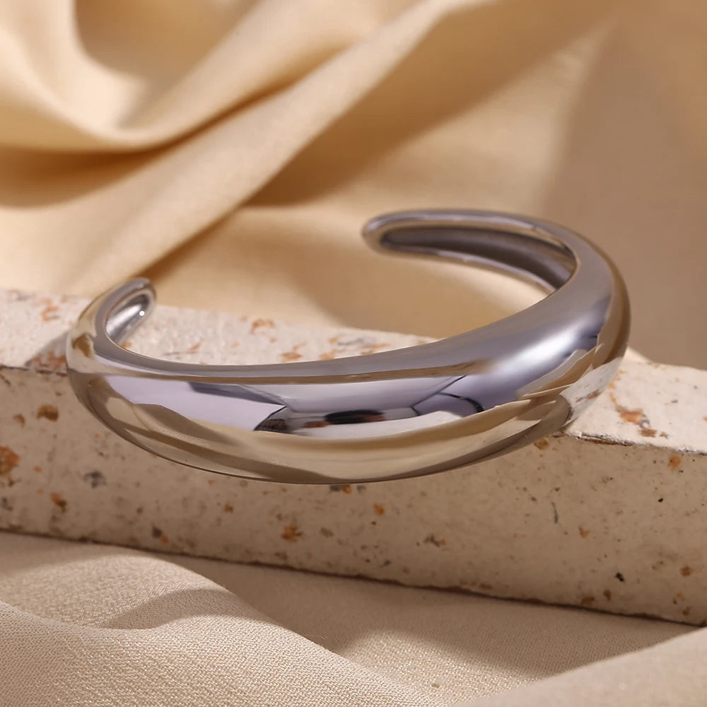 A sleek, silver statement bangle bracelet with a polished finish