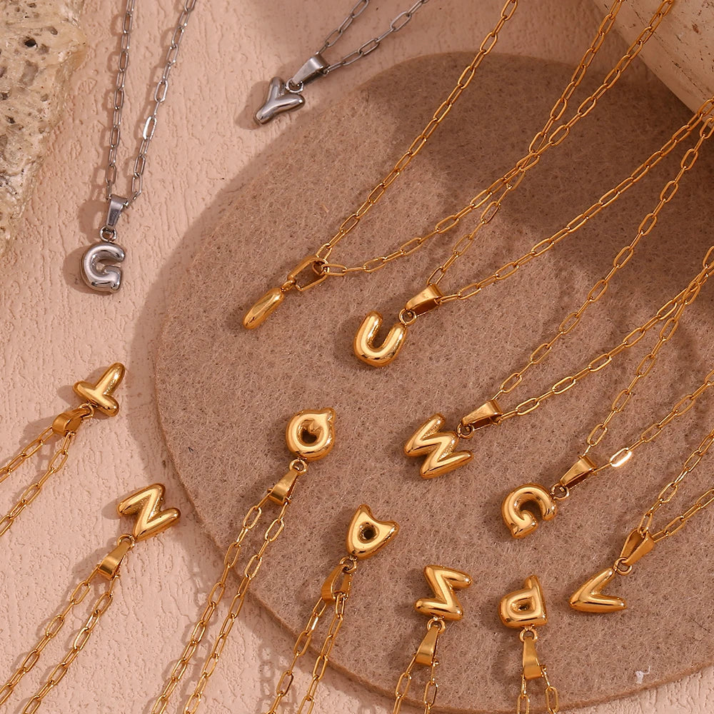 Necklaces with letter pendants on a textured surface