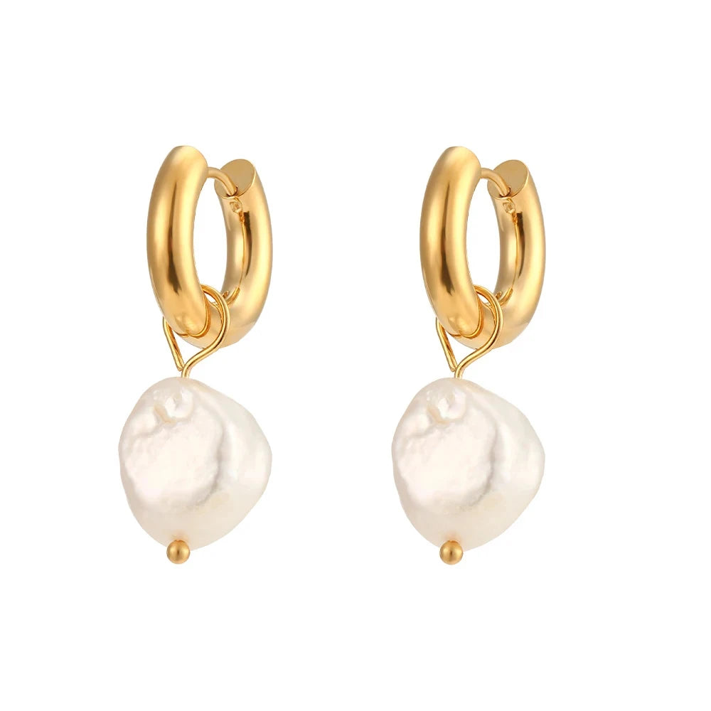 Gold hoop earrings with white pearls on a white background