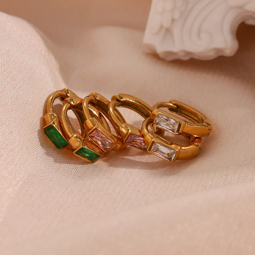 Gold ring with gemstones on a beige fabric background