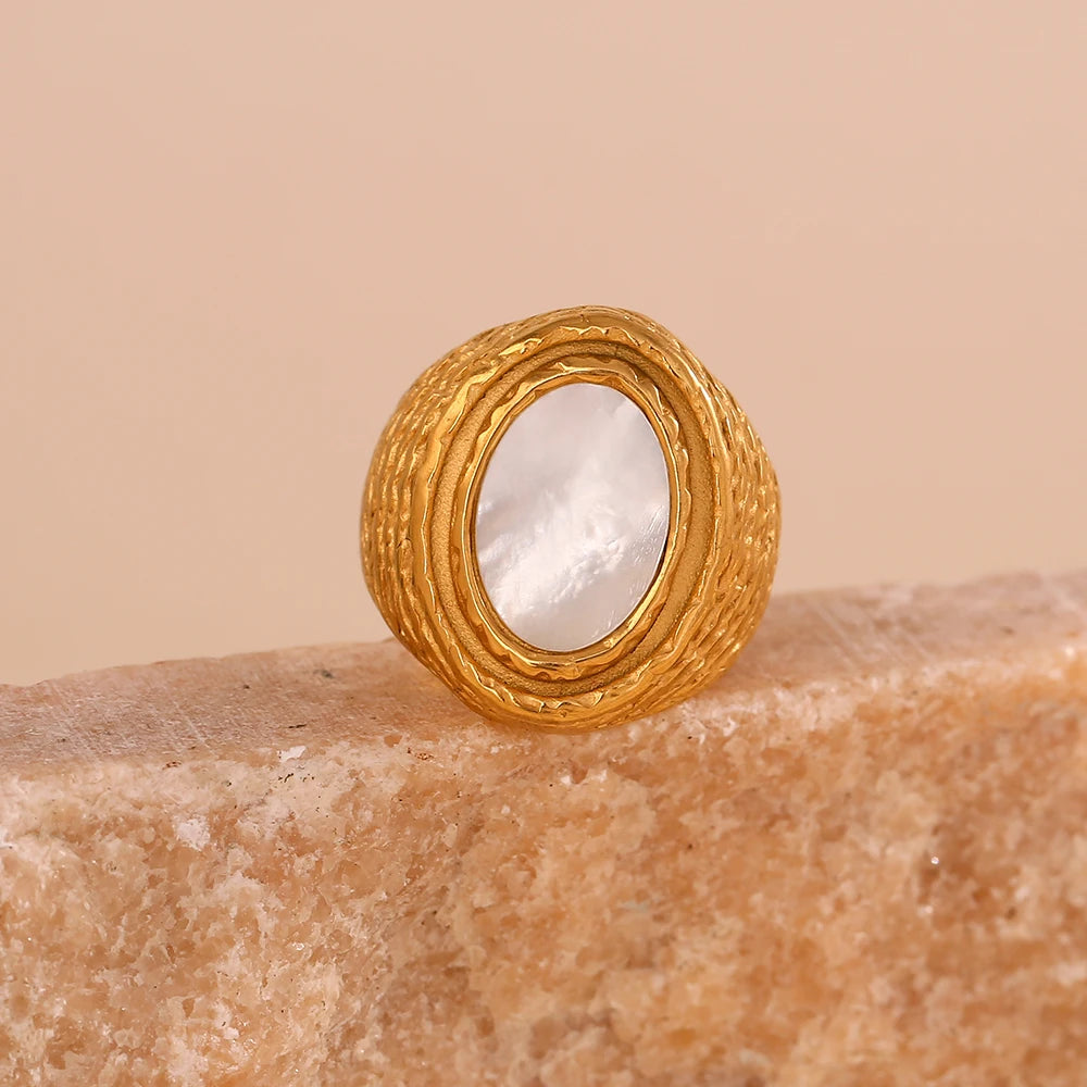 A chunky gold stainless steel ring with a natural white shell inset