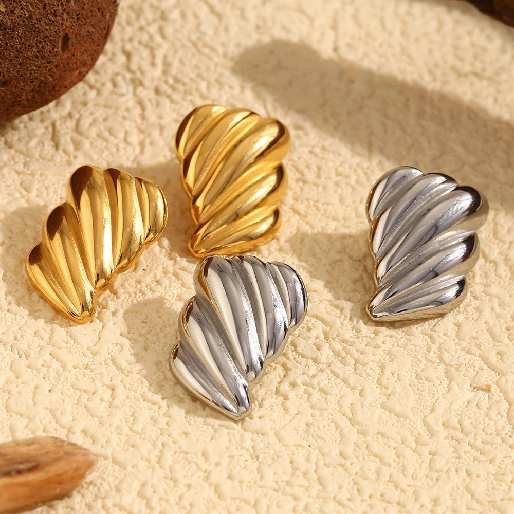 A pair of 18K gold plated or silver stainless steel earrings with a sculpted, wave-like design.