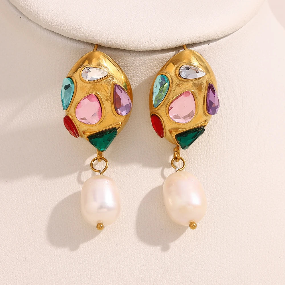 Colorful gemstone earrings with pearl drops on a beige background