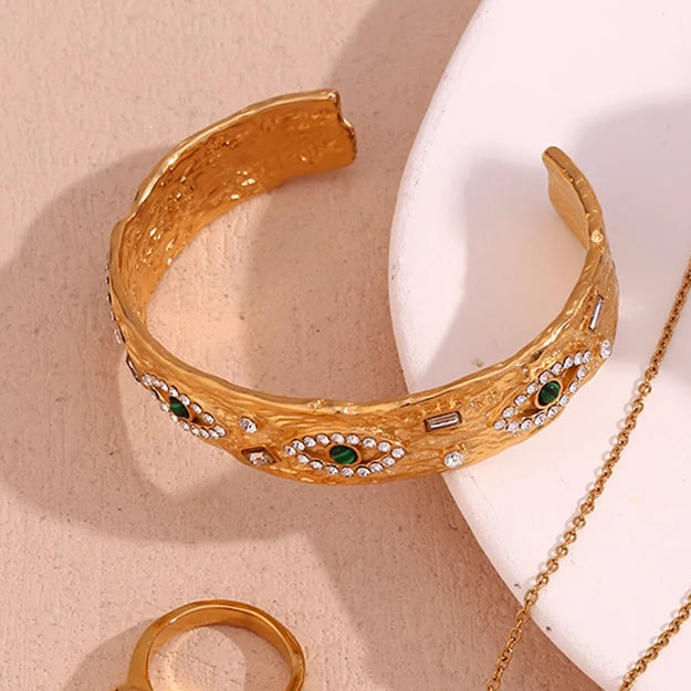 Gold hammered cuff  bracelet with malachite on a beige background
