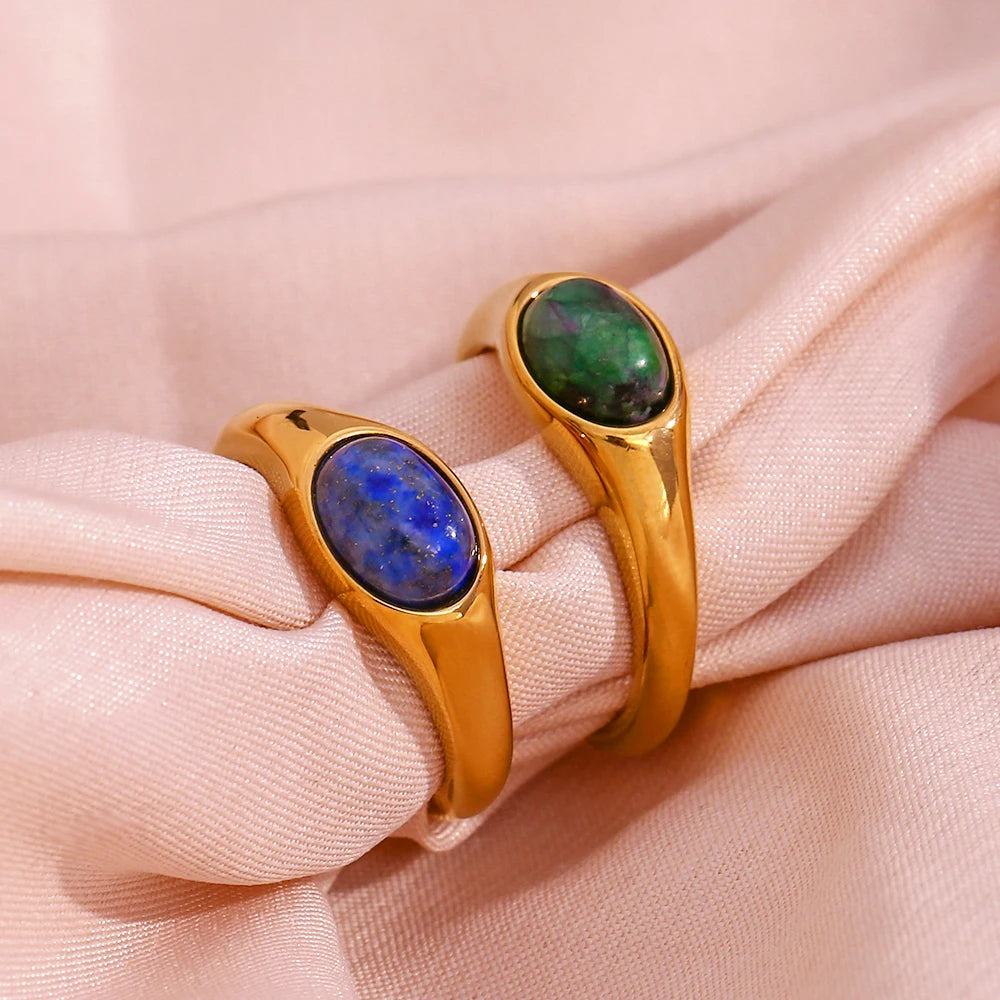 Golden rings with an oval blue or green gemstones set in the center,