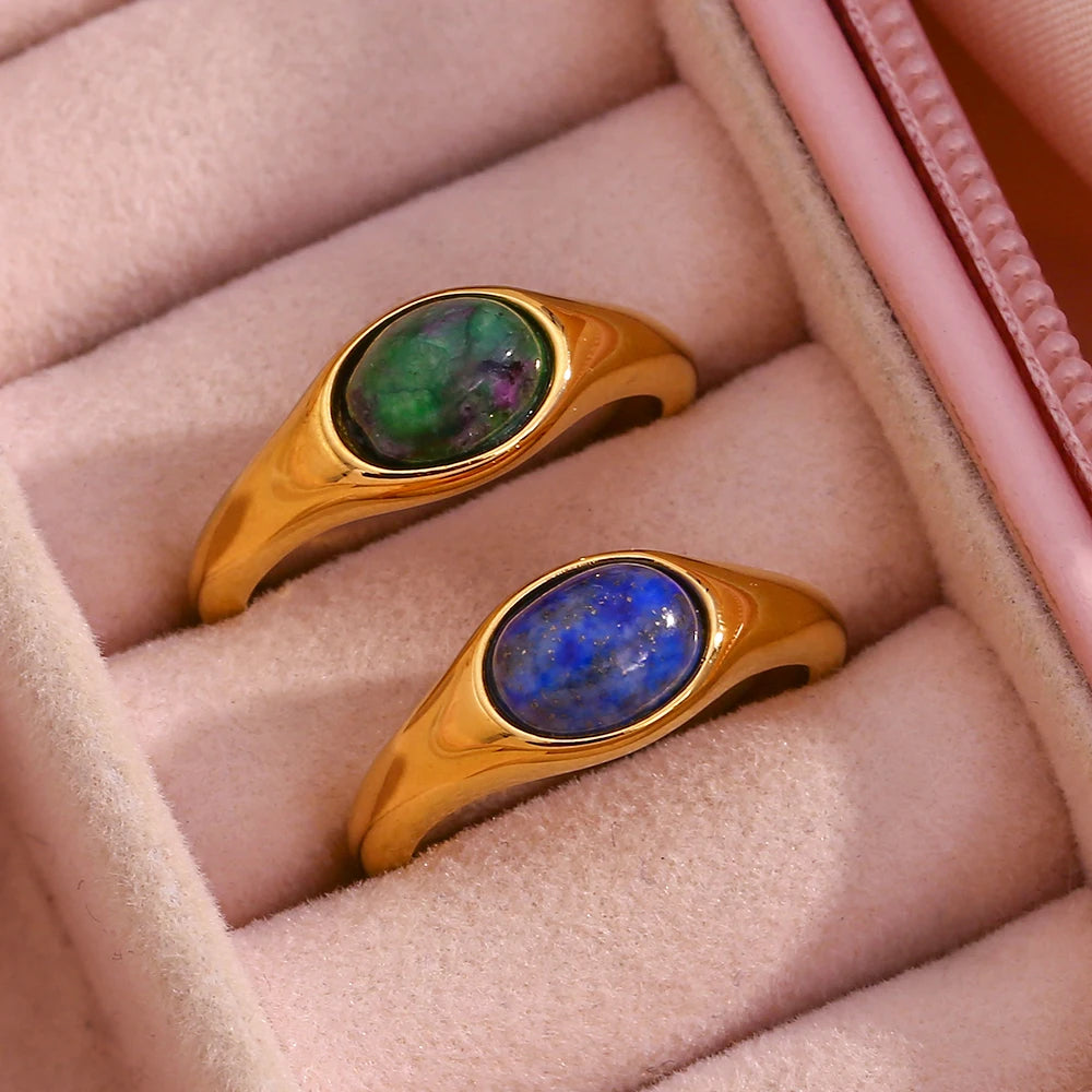 Golden rings with an oval blue or green gemstones set in the center,