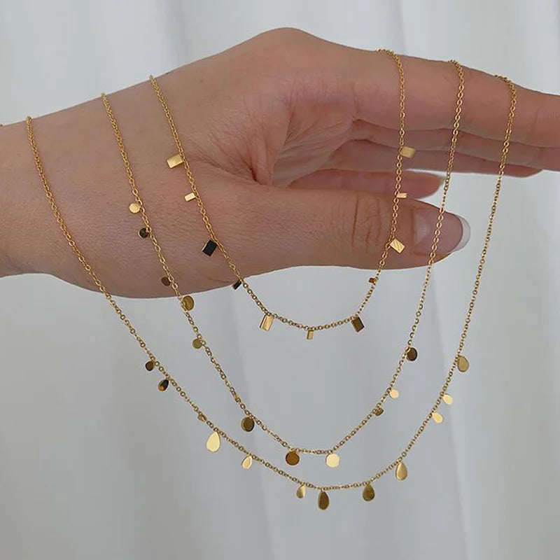 gold-plated stainless steel necklaces with multiple tiny discs attached to a chain, creating a shimmering effect.