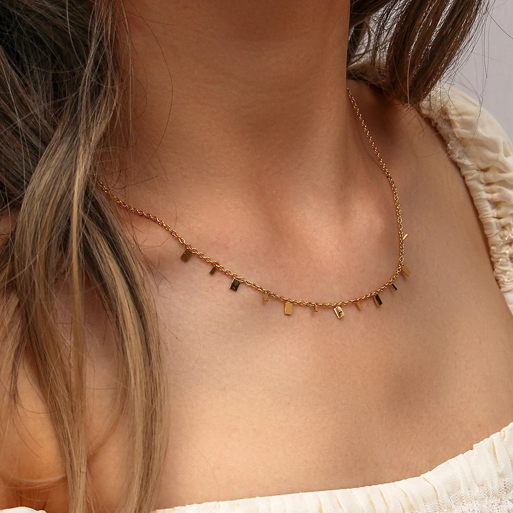 gold-plated stainless steel necklace with multiple tiny discs attached to a chain, creating a shimmering effect.