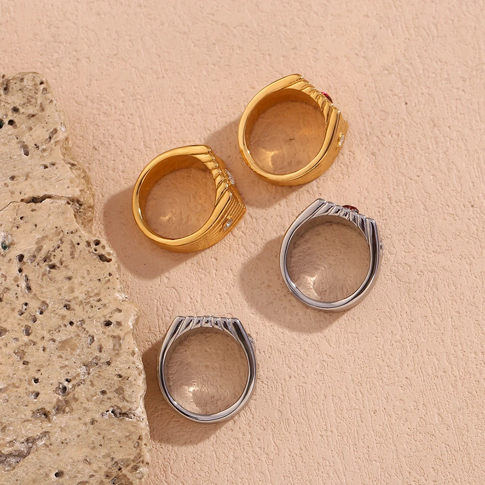 Stainless steel signet rings with a geometric design and crystal accents, featuring a prominent heart shaped zirconia at the top.