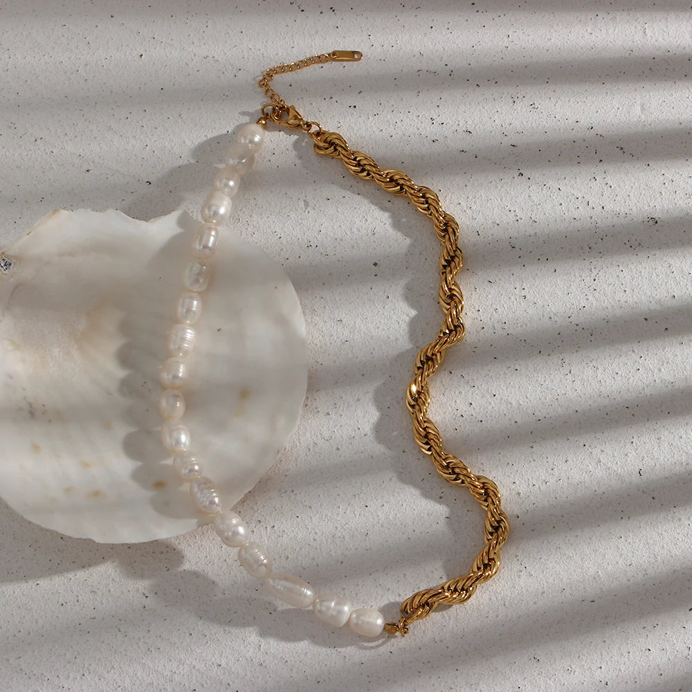 Pearl necklace with gold clasp on a textured white surface