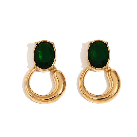 A pair of gold-colored earrings with deep green or black oval stones set in a loop design.