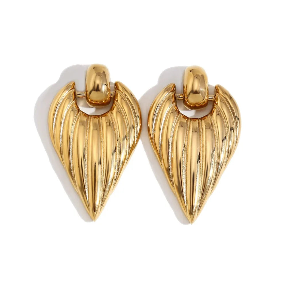 A pair of golden pointed earrings with a textured design, attached to a white background.