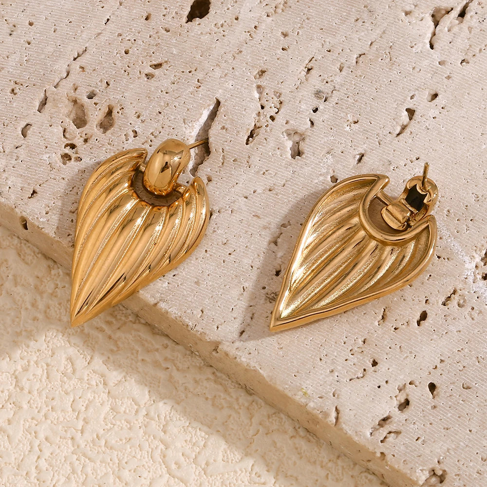 A pair of golden point earrings with a textured design, closeup from front and back side
