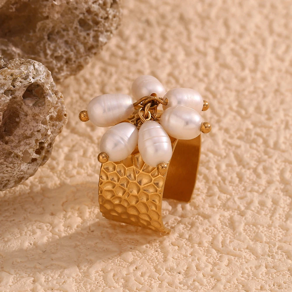 An 18K gold plated stainless steel ring with natural pearl embellishments, featuring a textured design and an adjustable band.