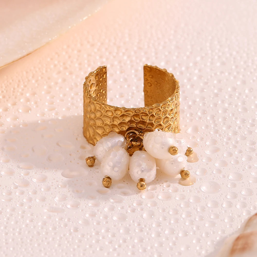 An 18K gold plated stainless steel ring with natural pearl embellishments, featuring a textured design and an adjustable band.