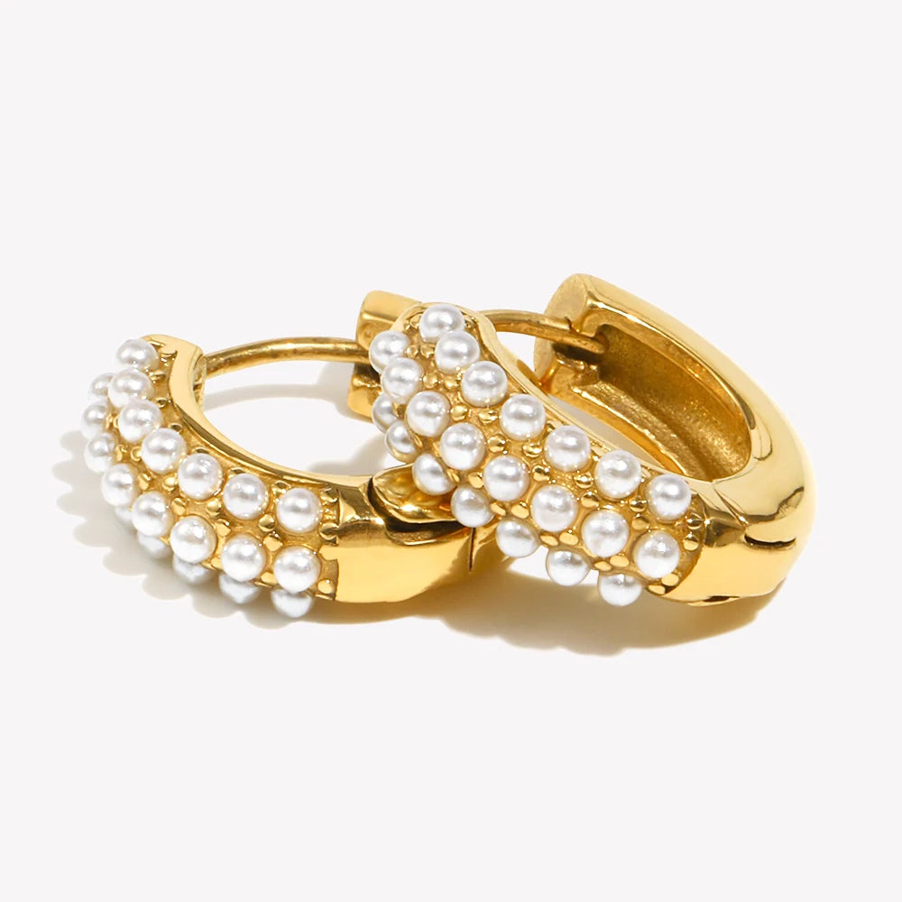 Gold hoop earrings with pearl accents on a white background