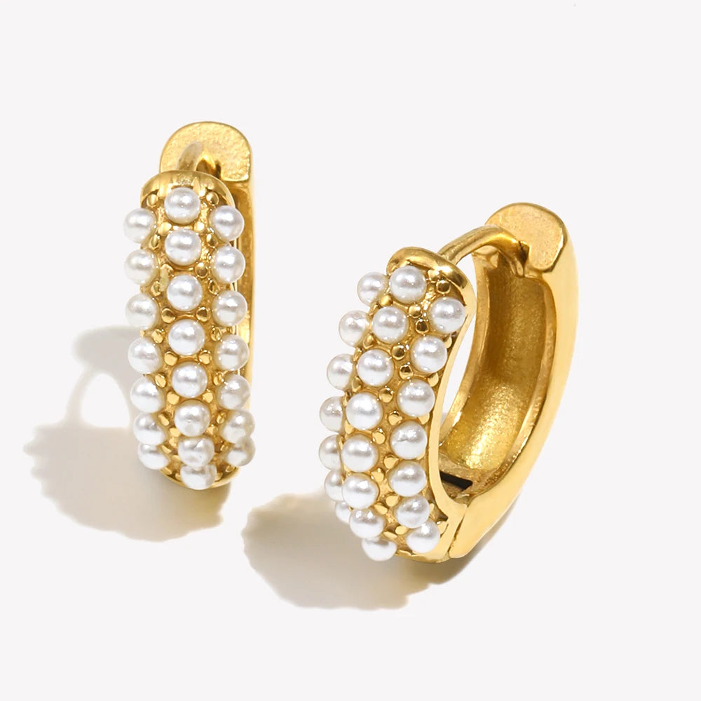 Gold hoop earrings with pearl accents on a white background