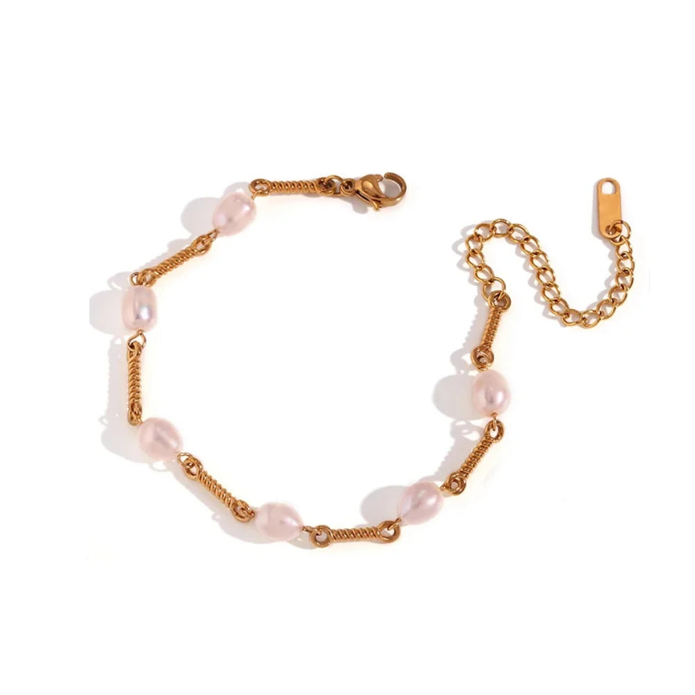 A bracelet with golden bars and natural pearls, featuring a clasp mechanism.