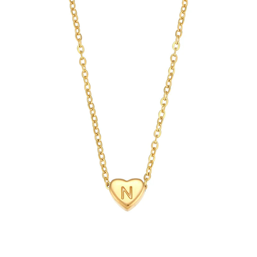 Gold necklace with a heart-shaped pendant featuring the letter 'N' on a white background