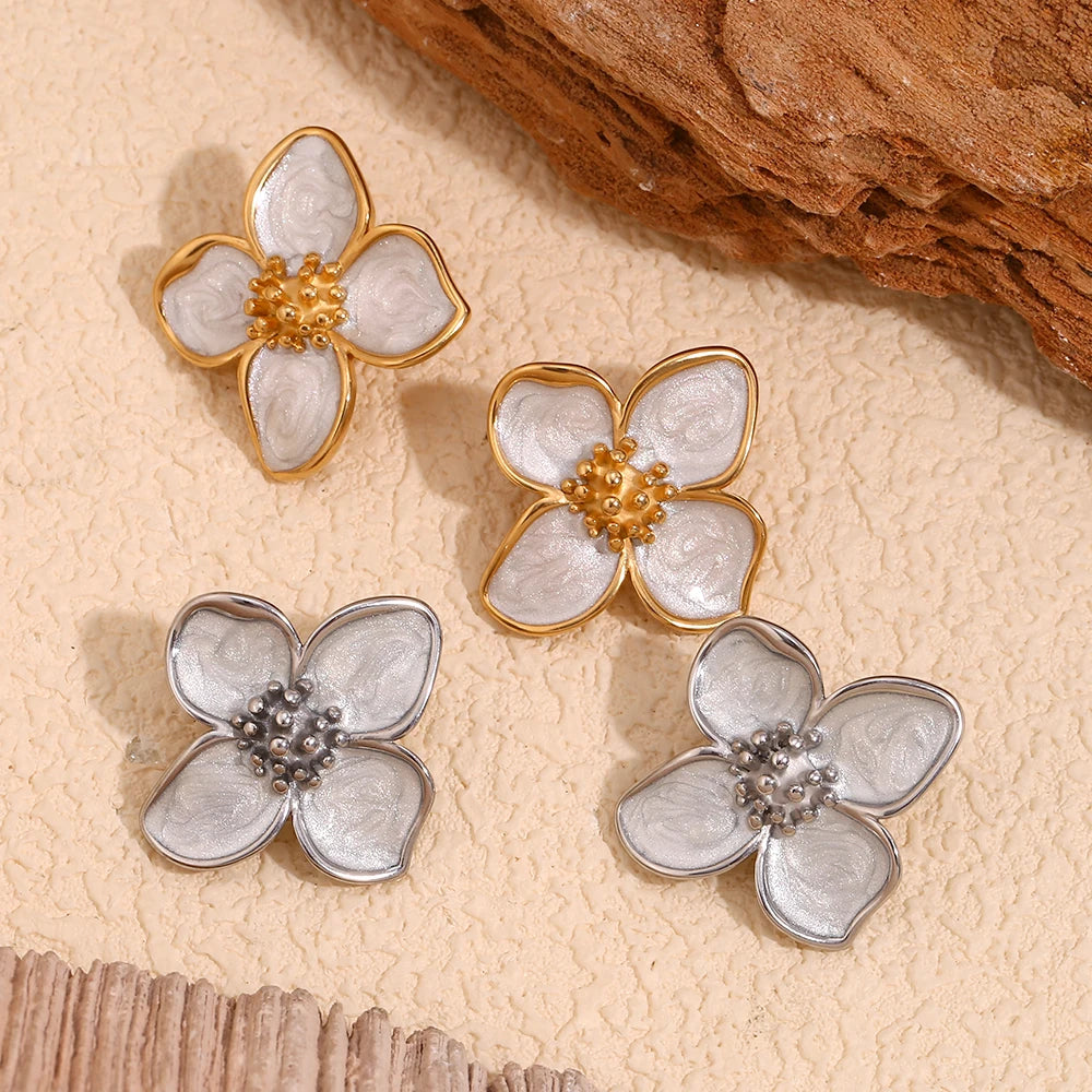 A pair of 18K gold coated or silver colored floral earrings with white enamel petals