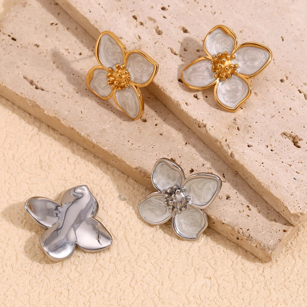 A pair of 18K gold coated floral earrings with white enamel petals from the back