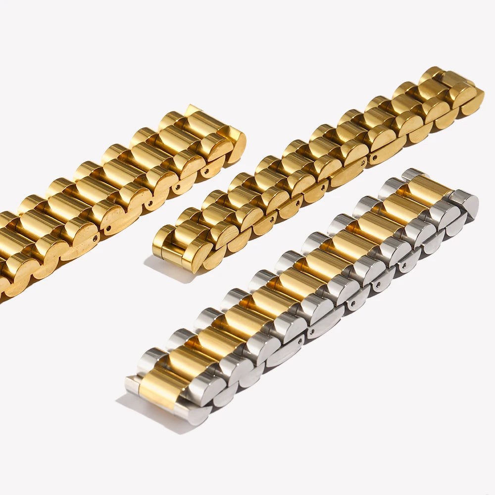 Gold and silver steel watch links on a white background