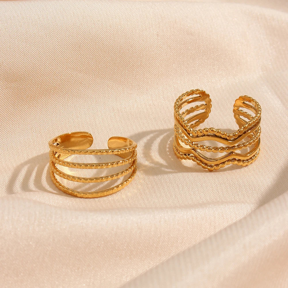 A gold-coated stainless steel ring with four bands that are merging into one