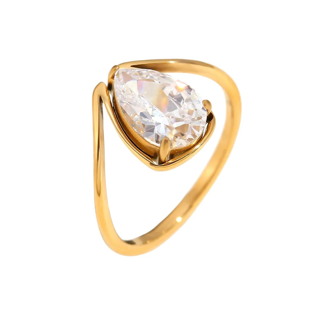A gold stainless steel ring with a large teardrop-shaped clear zirconia centerpiece.